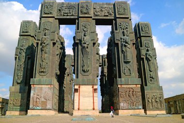 Gürcistan Günlüğüne Saygı duyan Kadın Ziyaretçi. Dev bir 16 Sütun Approx. Gürcistan 'ın Tiflis yakınlarında 30 metre uzunluğunda bir anıt.