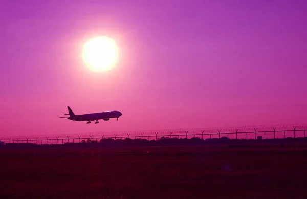 아트는 자주색 하늘로 날아가는 비행기의 실루엣 장식을 — 스톡 사진