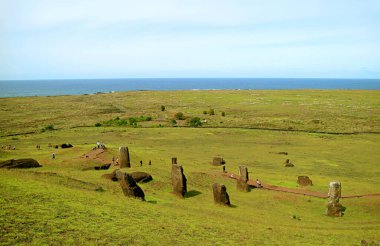 Rano Raraku yanardağındaki terk edilmiş dev Moai heykelleri ve Paskalya Adası, Şili 'deki Pasifik Okyanusu' nu ziyaret eden bir grup ziyaretçi.