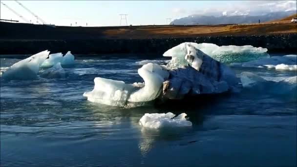 Iceberg coulant parmi les icebergs flottants sur la lagune du glacier Jokulsarlon, une journée ensoleillée d'automne en Islande — Video
