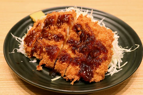 Tonkatsu ya da Japon usulü domuz pirzolası. Kalın kahverengi sos ve doğranmış lahana soslu.