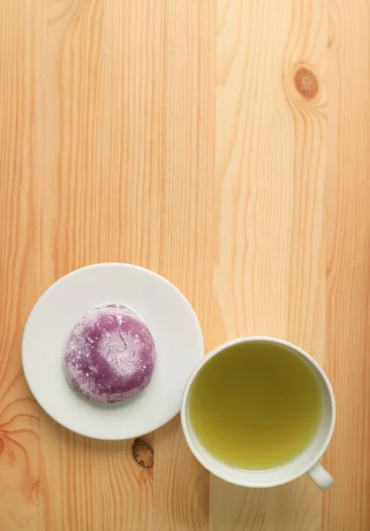Top View of Japanese Purple Sweet Potato Daifuku or Red Bean Paste Filling Rice Cake with Green Tea on Wooden Table