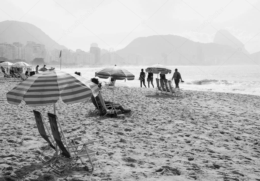 Monochrome image of group of people enjoy the activities on the sandy beach