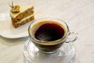 Arka planda ev yapımı havuçlu kek ve sıcak bir fincan kahve.