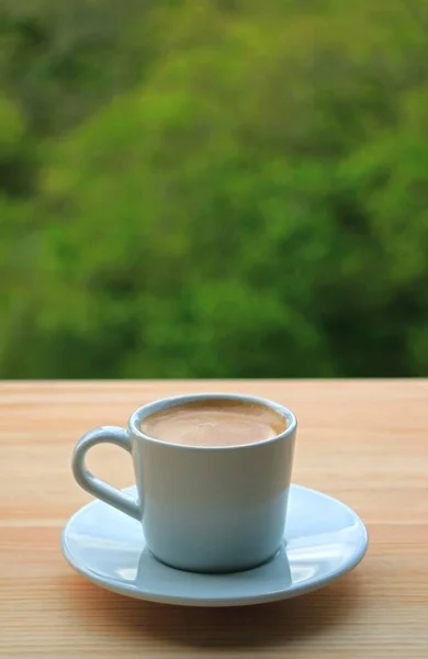 Чашка Пенного Кофе Фоне Размытой Зеленой Листвы — стоковое фото