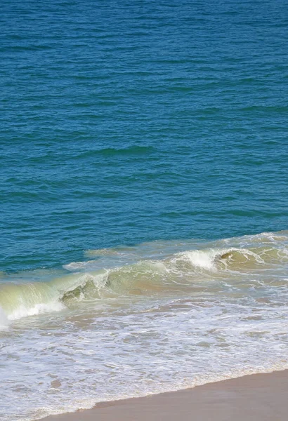 Big ocean waves crashing on the empty sandy beach