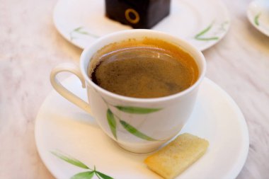 Beyaz Masa 'da servis edilen bir fincan samur kurabiyeli sıcak kahve.