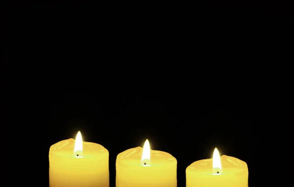 Shining Three Yellow Candles Zwarte Achtergrond Met Kopieerruimte — Stockfoto