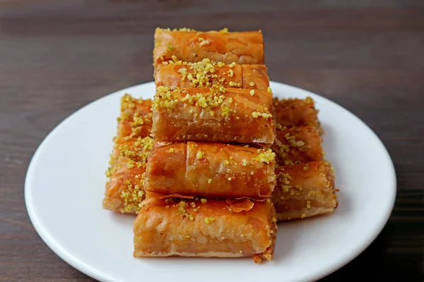 Teller Mit Baklava Gebäck Mit Gehackten Pistaziennüssen Auf Dunkelbraunem Holztisch — Stockfoto