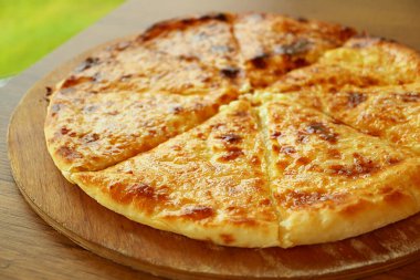 Closeup of Fresh Baked Khachapuri Imeruli (Imeretian) or Cheese-filled Georgian Flatbread on Wooden Plate