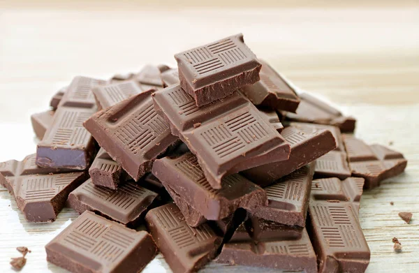 Montón Deliciosos Trozos Chocolate Sobre Fondo Madera — Foto de Stock
