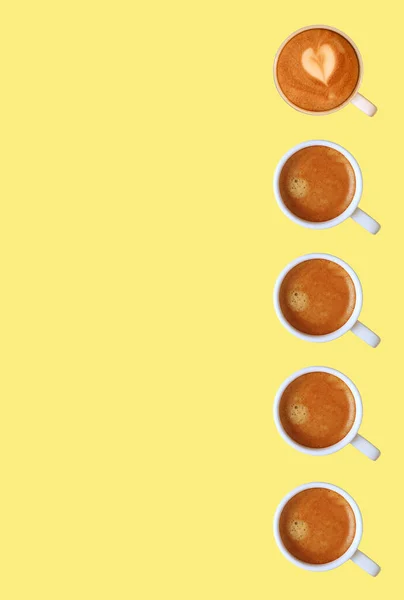 发泡浓缩咖啡在黄背景下的垂直排位 — 图库照片