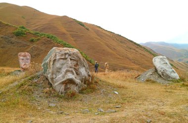 Gürcistan 'ın Sno Village, Gürcistan' daki Kafkasya eteklerindeki ünlü tarihsel figürlerin dev baş heykelleri sahasına gelen ziyaretçi.