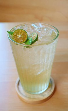 Thai Eastern Style Tangy Iced Calamansi Citrus Juice on Wooden Background