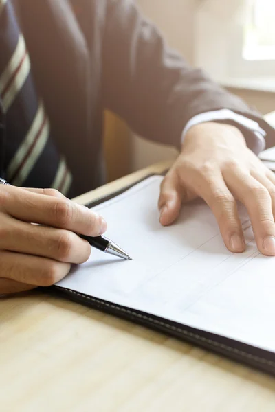 Menselijke Hand ondertekening op formele papier op de werkplek — Stockfoto