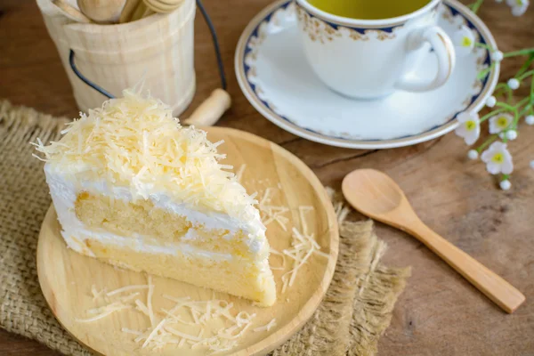 Bolo de queijo com colher de madeira e xícara de chá — Fotografia de Stock