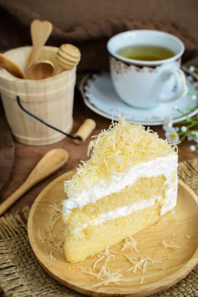 Bolo de queijo com colher de madeira e xícara de chá — Fotografia de Stock