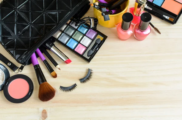Maquillage avec des cosmétiques et brosses sur table en bois — Photo