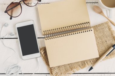 cep telefonu ve kulaklık ile bir fincan kahve Beyaz ahşap masa