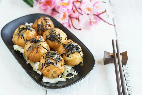 Primer plano de takoyaki en mesa de madera con palillos — Foto de Stock