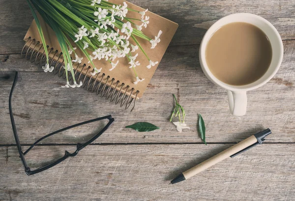 Kopp kaffe med anteckningsbok på träbord — Stockfoto