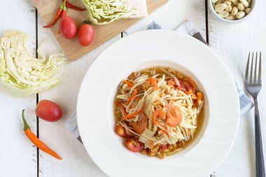 Papaya salatası beyaz tahta masada ünlü Tayland gıda