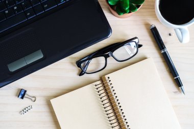 Boş defter ile dizüstü bilgisayar ve bir fincan kahve