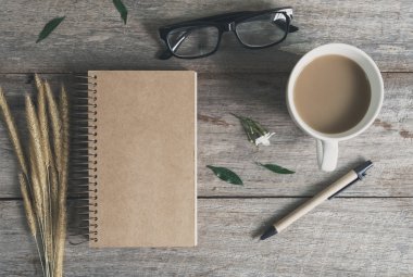 Ahşap masa üstünde defter ile kahve