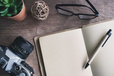 Eski ahşap masa üstünde boş defter ile Retro kamera