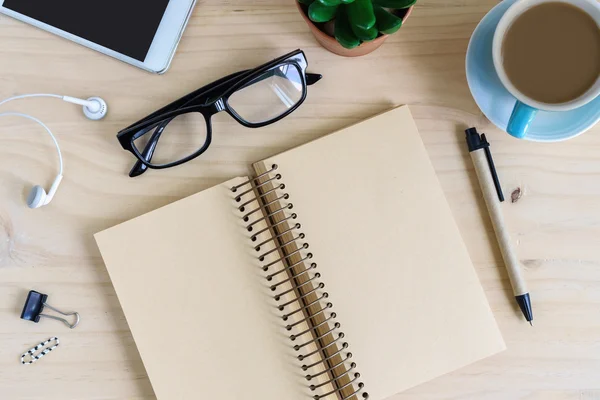 Blank notebook with earphone and a cup of coffee on wooden desk — Stock Photo, Image