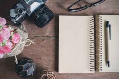 Eski ahşap masa üstünde boş defter ile Retro kamera