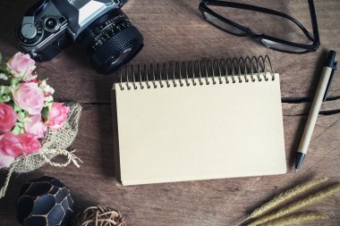 Eski ahşap masa üstünde boş defter ile Retro kamera