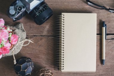 Eski ahşap masa üstünde boş defter ile Retro kamera