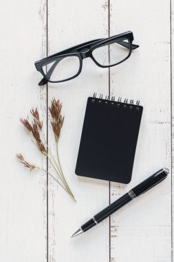 Beyaz ahşap zemin üzerinde kuru çiçek ile not etmek