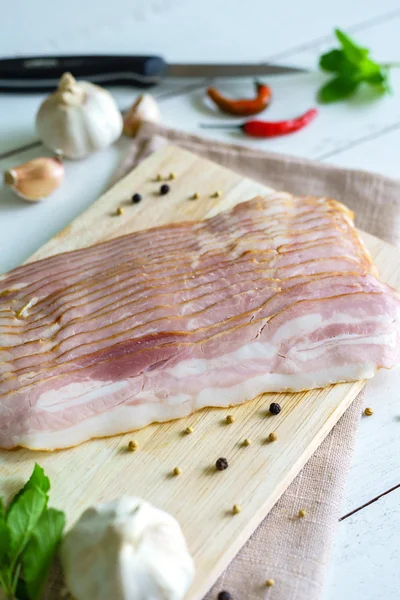 Fette di pancetta sullo sfondo di legno — Foto Stock