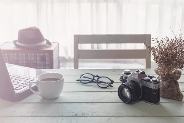 Taza de café y cuaderno sobre mesa de madera con luz solar — Foto de Stock