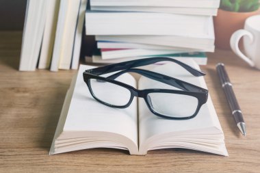 Ahşap masa, eğitim arka plan üzerinde kitap yığını