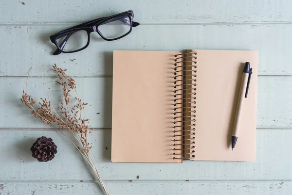 Dry flower with blank notebook on old wooden table — Stock Photo, Image