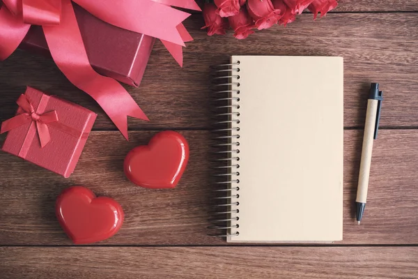 Offenes Notizbuch mit Geschenkbox und roter Herzform — Stockfoto
