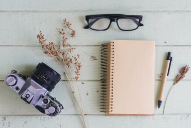 Eski ahşap masa üstünde boş defter ile Retro kamera