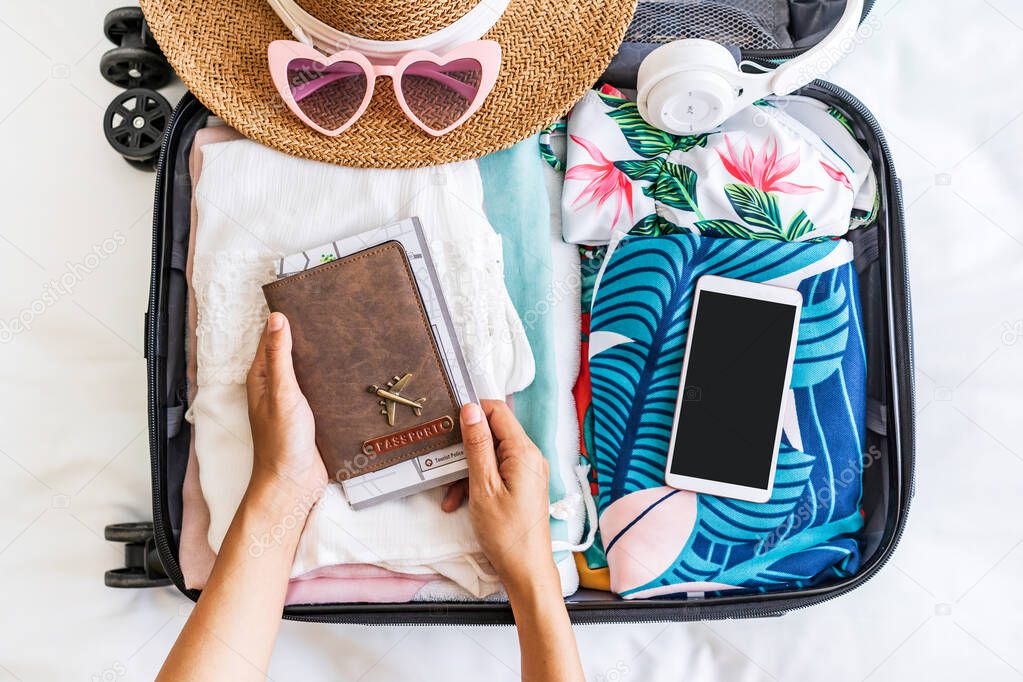 Young woman traveler holding passport with suitcase and luggage ready for travel