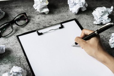 Masasında buruşuk kağıt topları olan dosya klasörüne el yazısı, yaratıcılık sorunları kavramı