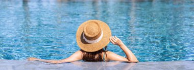 Genç bayan gezgin yaz tatili ve seyahat konsepti için seyahat ederken tropik bir tatil havuzu kenarında dinleniyor ve eğleniyor.