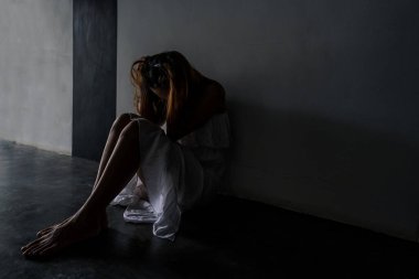 Yalnız genç bir kadın kendini depresyonda ve stresli hissediyor. Karanlık bir yolda oturuyor. Negatif duygular ve zihinsel sağlık konsepti.