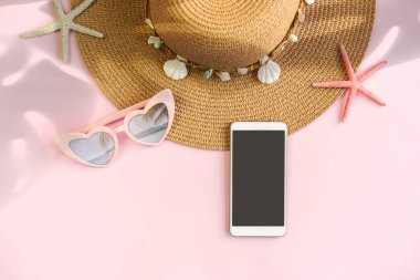 Fotokopi alanı ve yaz tatili kavramına sahip renk arkaplanı üzerinde boş ekran akıllı telefona sahip seyahat aksesuarları ögeleri