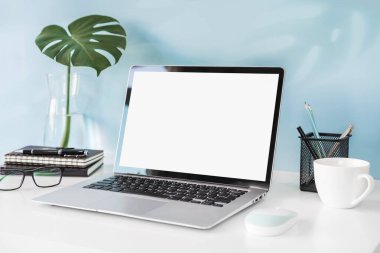 Modern ve şık çalışma alanı boş dizüstü bilgisayar ve masa başı ofis malzemeleriyle renkli arka plan ve kopyalama alanı oluşturur.