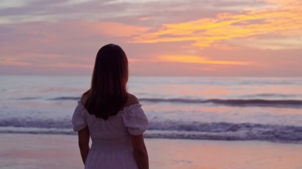 ビーチに立って夕日を見ている孤独な若いアジアの女性 — ストック動画
