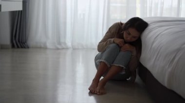 Yalnız genç bir kadın, karanlık bir odada otururken depresyonda ve stresli hissediyor, negatif duygular ve akıl sağlığı kavramı.