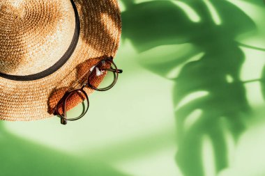 Fotokopi alanı, yaz tatili konsepti ve renk arkaplan üzerinde tropikal yeşil izinli şapka ve güneş gözlüğü