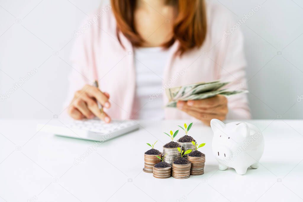 Young woman calculating expenses with stack of coins and piggy bank, Saving money for future investment concept